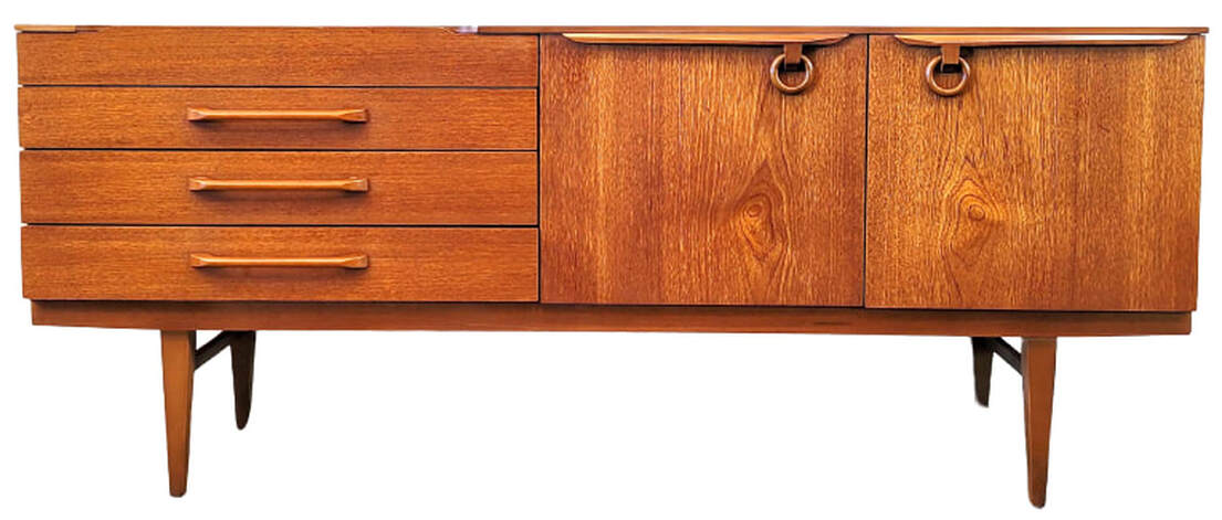 Beautility vintage teak credenza is fitted with four storage drawers on the left. The top drawer is lined and fitted with removeable spacers for flatware storage. At center is a fall-front cocktail cabinet and at right is a single door cabinet containing one shelf. The doors open with a tug on the wooden ring pulls. The carcase stands atop tapered legs with side stretchers. 72