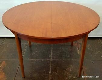 Extendable Round Table - Vintage Danish Modern dining table with Southeast Asian crown-cut teak top and Beech wood legs. Extends to oval with built-in butterfly leaf.