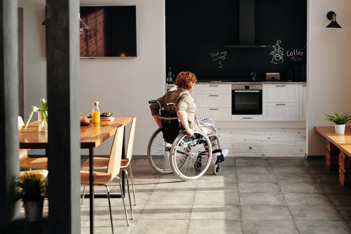 Woman on wheelchair entering kitchen