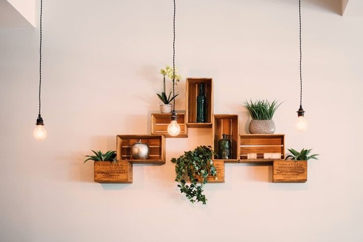 Three light bulbs hanging in front of crate shelving.