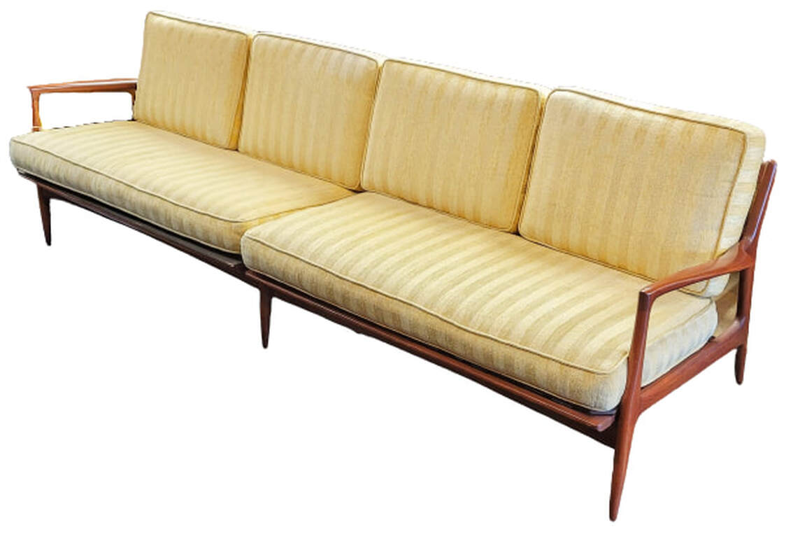 Mid-Century Modern four seat sofa designed by Ib Kofod-Larsen and manufactured in Denmark in 1958 for Selig. The walnut colored frame is set with two long yellow seat cushions and four matching yellow back cushions.