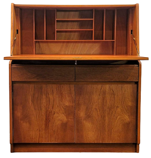 Remploy teak bureau with fall-front desk fitted with vertical and horizontal pigeon-holes for letters and correspondence; two frieze drawers; and one double-doored cabinet on a plinth base.
