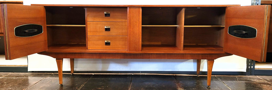 Stonehill Furniture Stateroom Credenza with Bifold Doors.  The interior of this credenza is fitted with three shelves with machined brass edging and three stacked storage drawers with inset pulls.