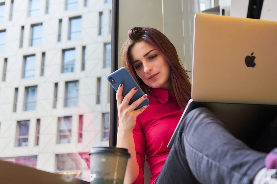 Woman with cell phone and laptop computer.